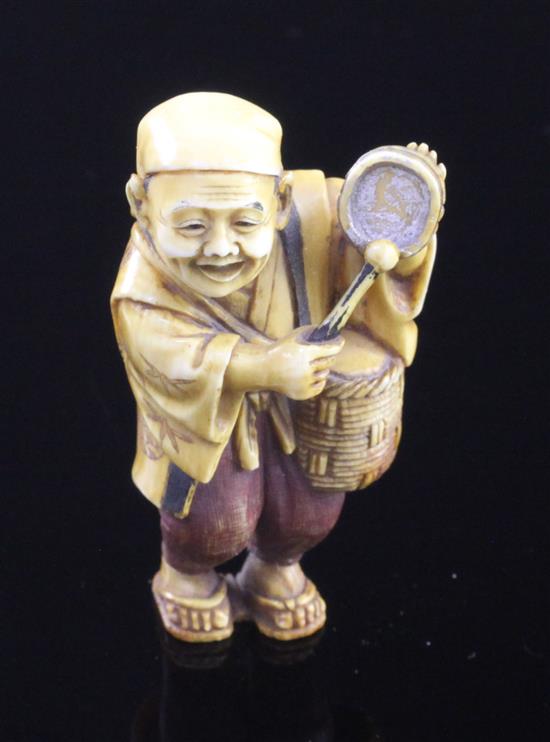 A Japanese tinted ivory figure of a street vendor, Taisho period, 5cm